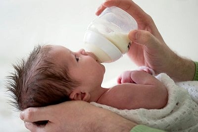 Father giving milk to baby (2-5 months)