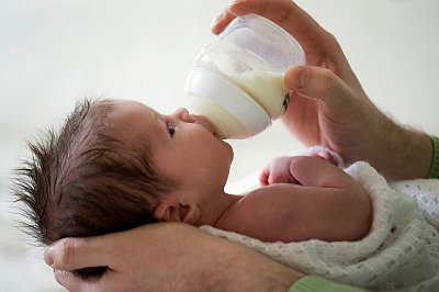 Father giving milk to baby (2-5 months)