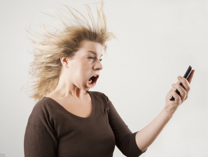 Studio shot of woman with windblown mouth holding phone