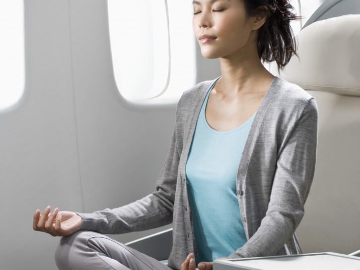 Woman meditating on airplane