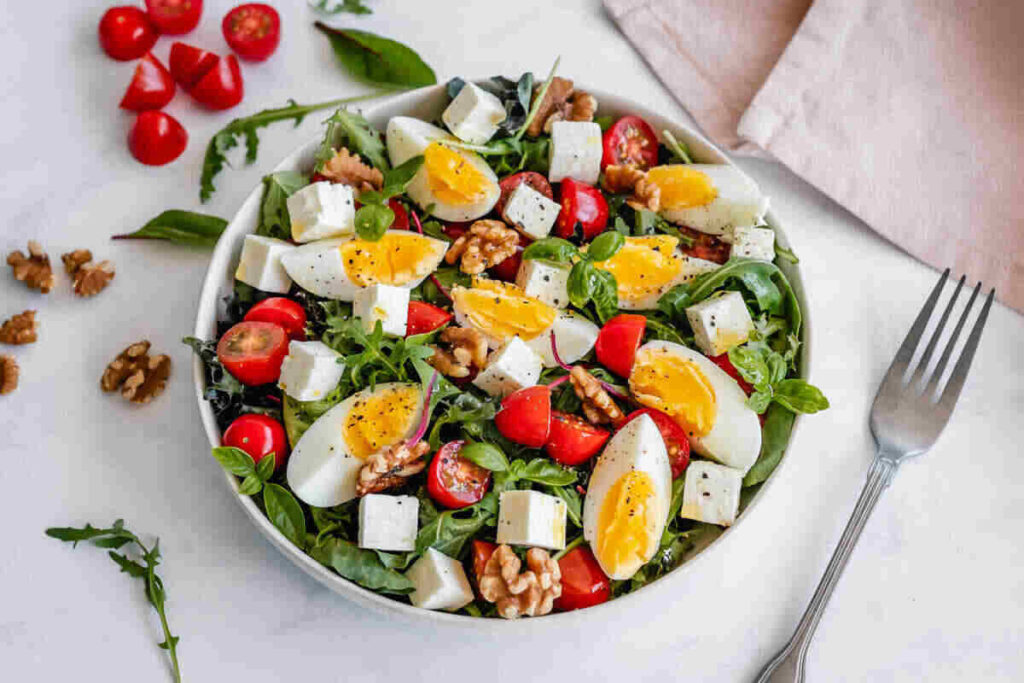 piatto di insalata estiva con uova soda, pomodorini e noci