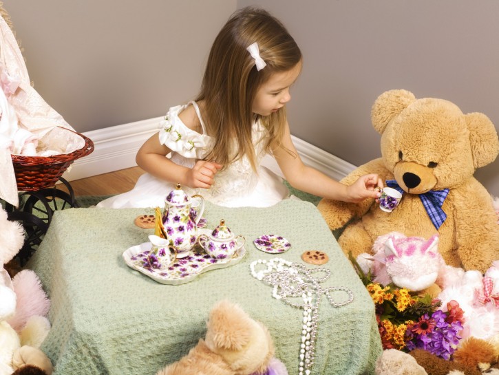 Girl having a tea party with teddy bears