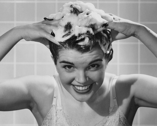 Young woman shampooing her hair