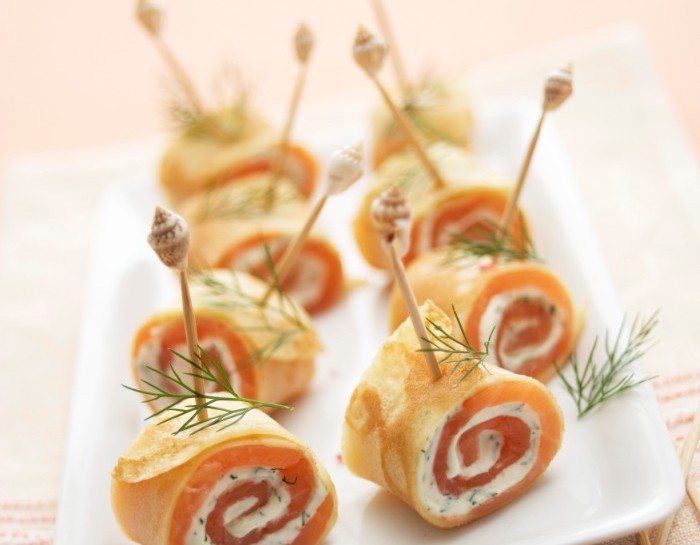 <p>Ingredienti</p><p>400 g di salmone affumicato</p><p>200 g di yogurt greco</p><p>Olio extravergine d’oliva</p><p>Erba cipollina</p><p>Pepe rosa</p><p>Un pizzico di curcuma</p><p>12 crepes</p><p>Questi <b>involtini di crepes</b> sono un piatto semplice da realizzare, l’antipasto ideale per una cena in compagnia oppure uno stuzzichino perfetto per un aperitivo fresco.</p><p>Vediamo insieme come prepararlo.</p><p>La prima cosa da fare è creare una salsina con lo <b>yogurt greco</b>: riponilo in una ciotola e aggiungi mezzo cucchiaino di <b>curcuma</b>, un pizzico di pepe rosa e uno di sale.</p><p>Lava sotto l’acqua corrente l’erba cipollina, poi sminuzzala finemente. Fai la stessa cosa con qualche foglia di basilico.</p><p>Aggiungi questi sapori allo yogurt e amalgama tutti gli ingredienti. Riponi la salsina in frigo per circa 15 minuti.</p>