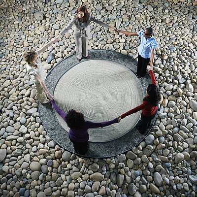Businesspeople Holding Hands Around Dry Landscape Garden