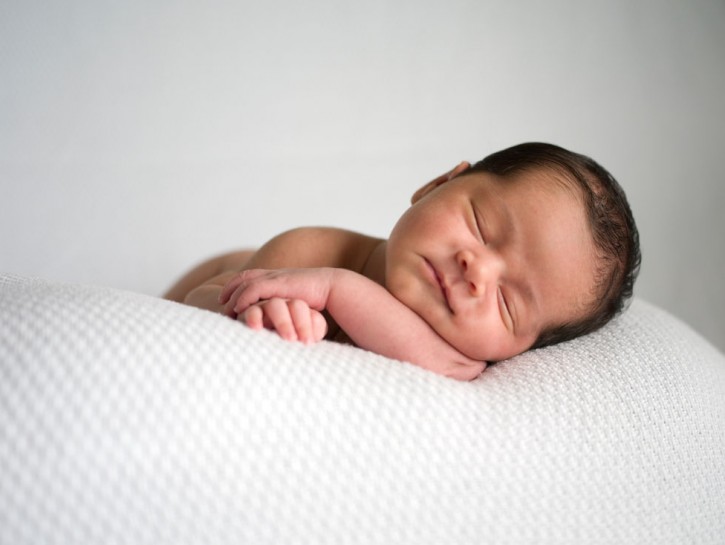 Naked newborn baby peacefully sleeping