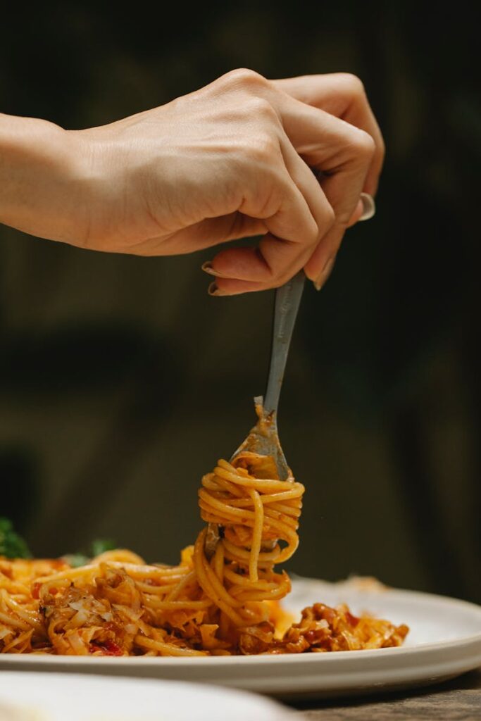 ragazza mangia un piatto di spaghetti