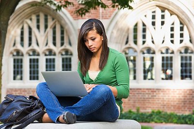 Mixed race student using laptop on campus