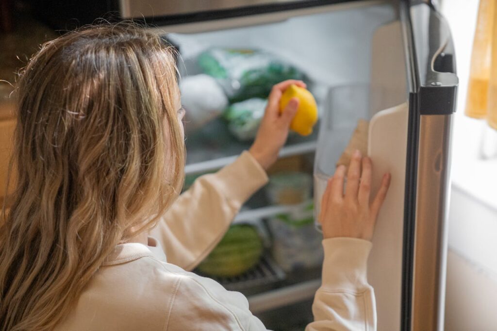 ragazza sta sistemando la spesa nel frigo
