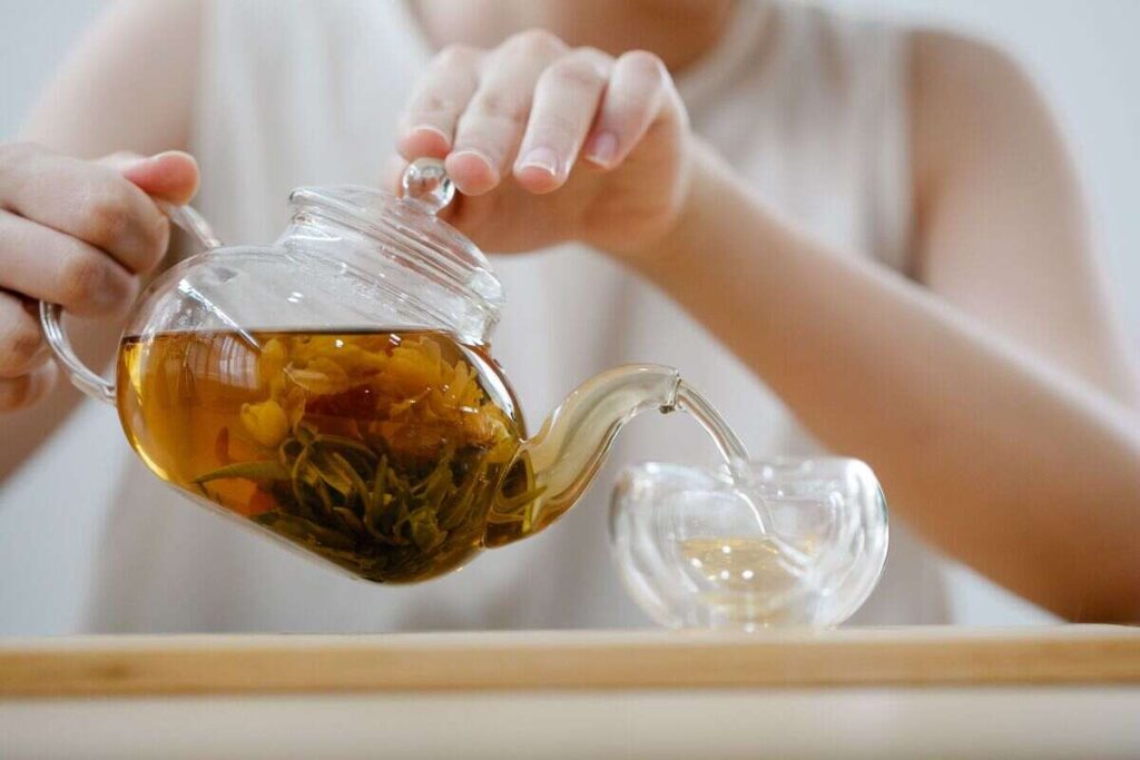 donna versa infuso nel bicchiere