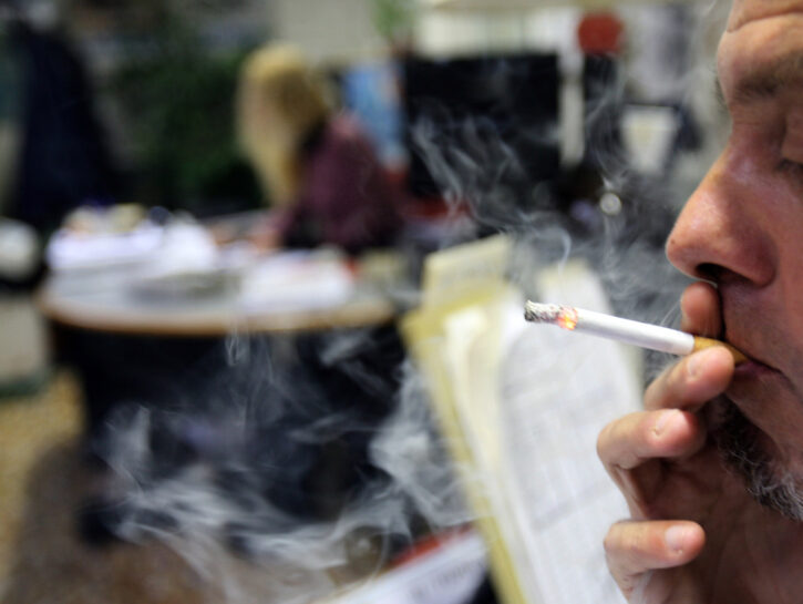 Uomo fuma una sigaretta in un ufficio