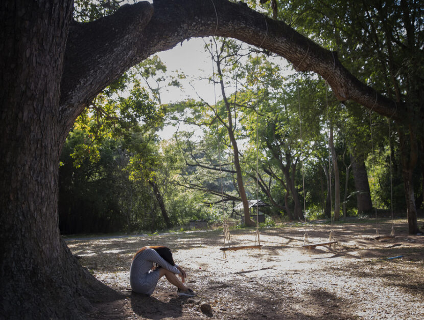 donna triste sotto un albero