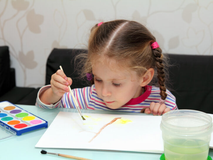 Bambina asilo colora acquerelli disegno