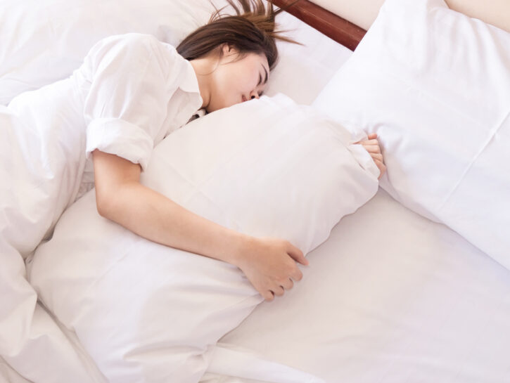 Donna a letto insonnia lenzuola bianche