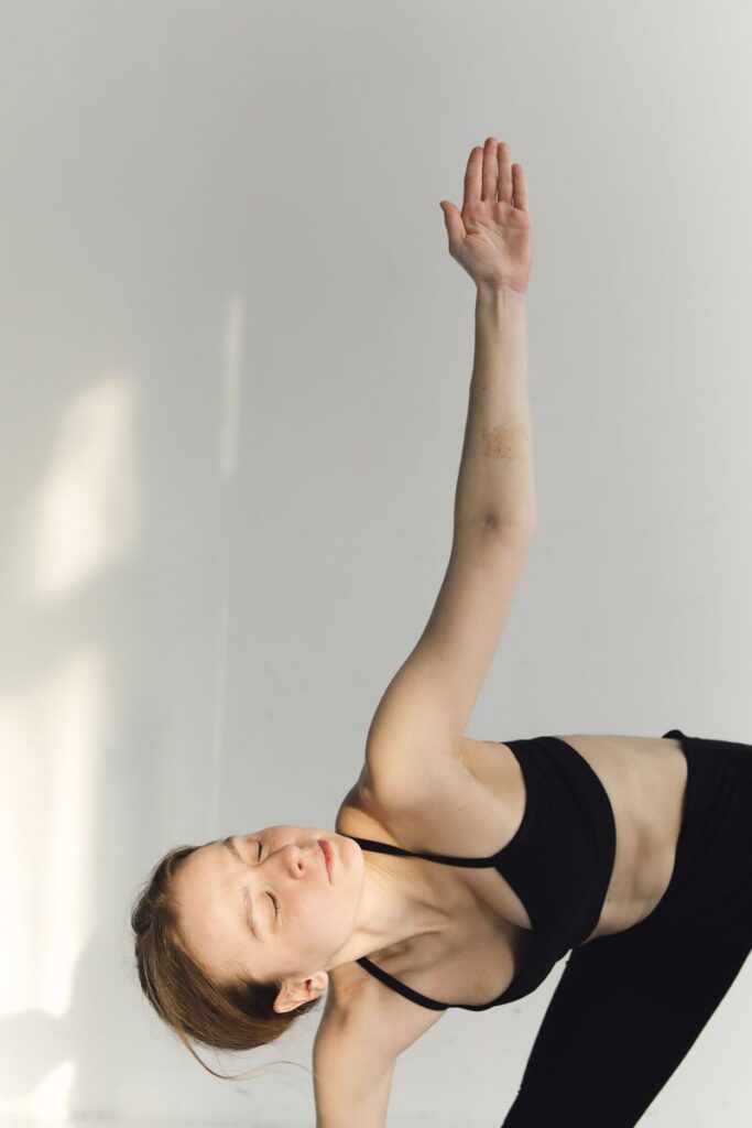 donna in completo sportivo che fa flessione laterale