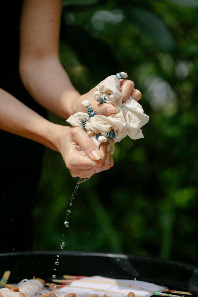 Mani di donna che strizzano un panno
