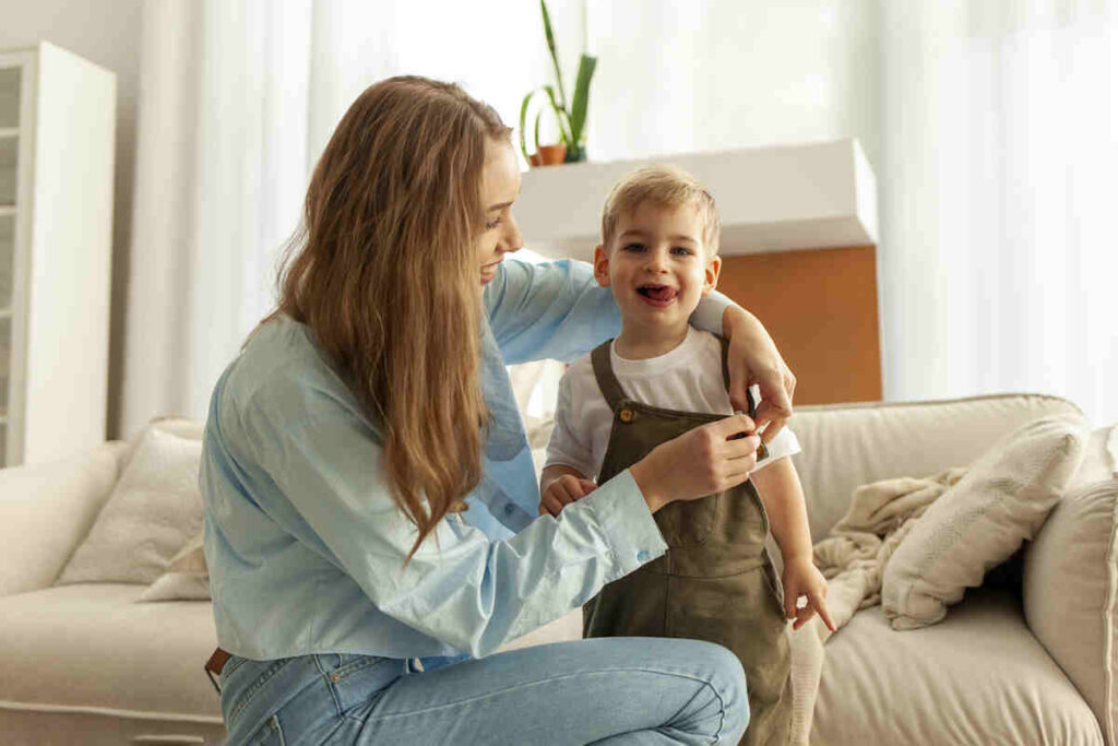 Mamma che aiuta il bambino a vestirsi