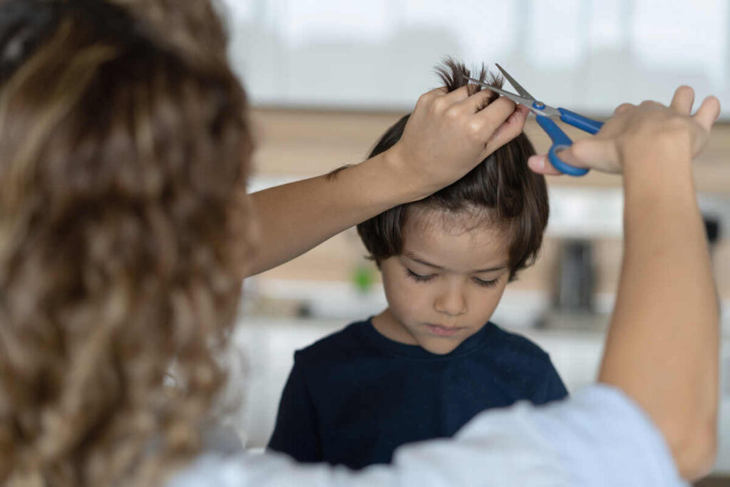 mamma che taglia capelli al bambino
