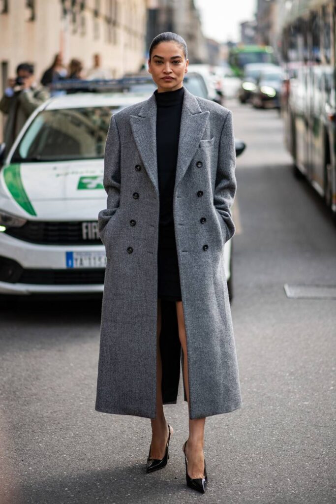 look per la sera: mini abito nero con cappotto lungo grigio e scarpe col tacco alto