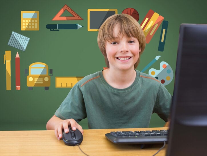 Bambino studia a scuola con computer