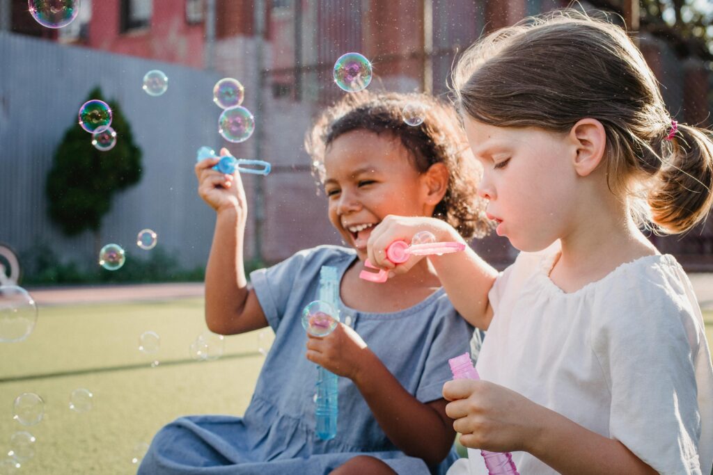 Bambini che giocano con le bolle di sapone