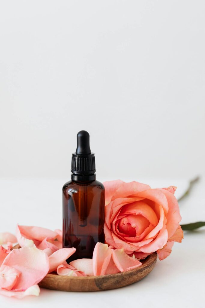 boccetta di olio essenziale su petali di rosa