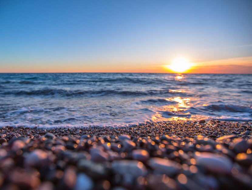 Tramonto sul mare spiaggia ciottoli