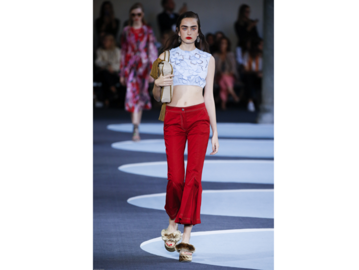 La modella indossa i pantaloni skinny rossi e un crop top azzurro di Marco De Vincenzo