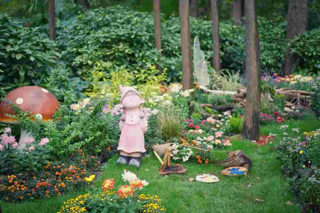 Giardino con oggetto in miniatura, fungo, fiori, cespugli e alberi