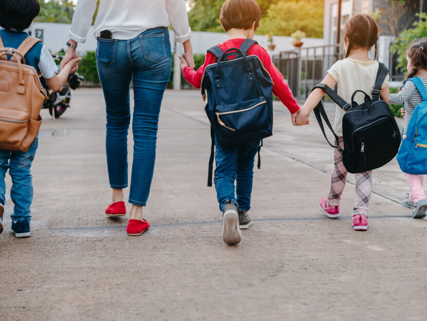 Mamma con bambini a scuola zaini