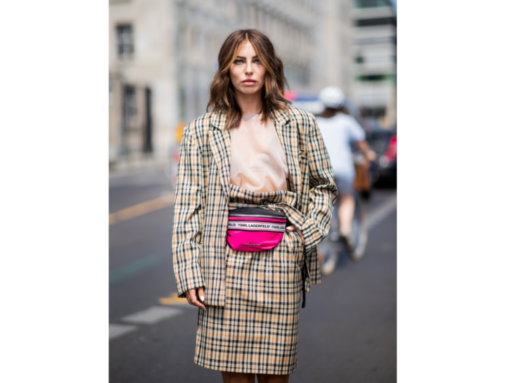 Il look classy del tailleur a quadretti diventa funny con il marsupio rosa shocking