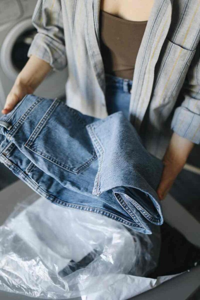 Donna con in mano un jeans piegato