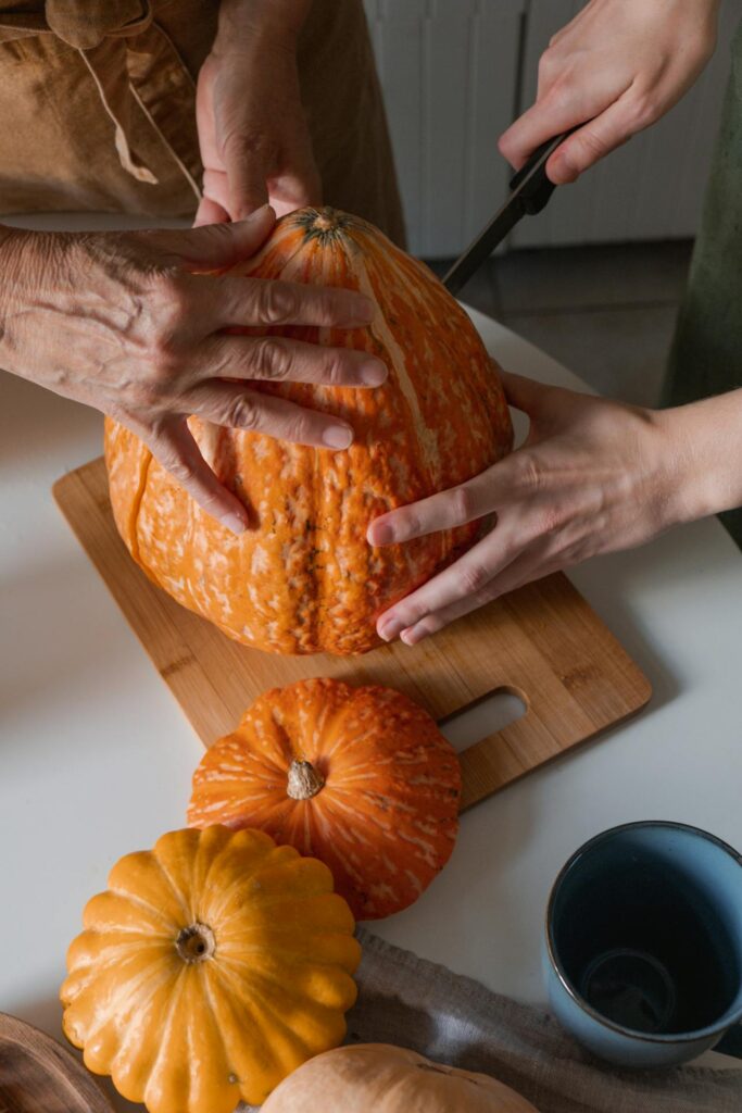 due donne stanno tagliando una zucca