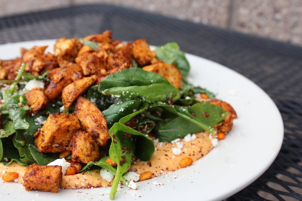 Pollo a pezzi su salsa con spinacino fresco