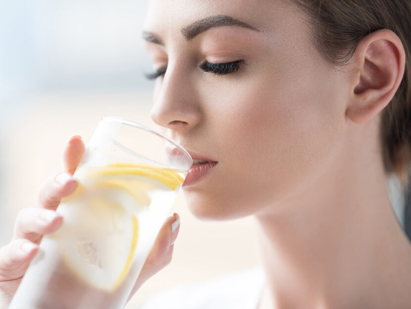 Donna beve bicchiere acqua limone