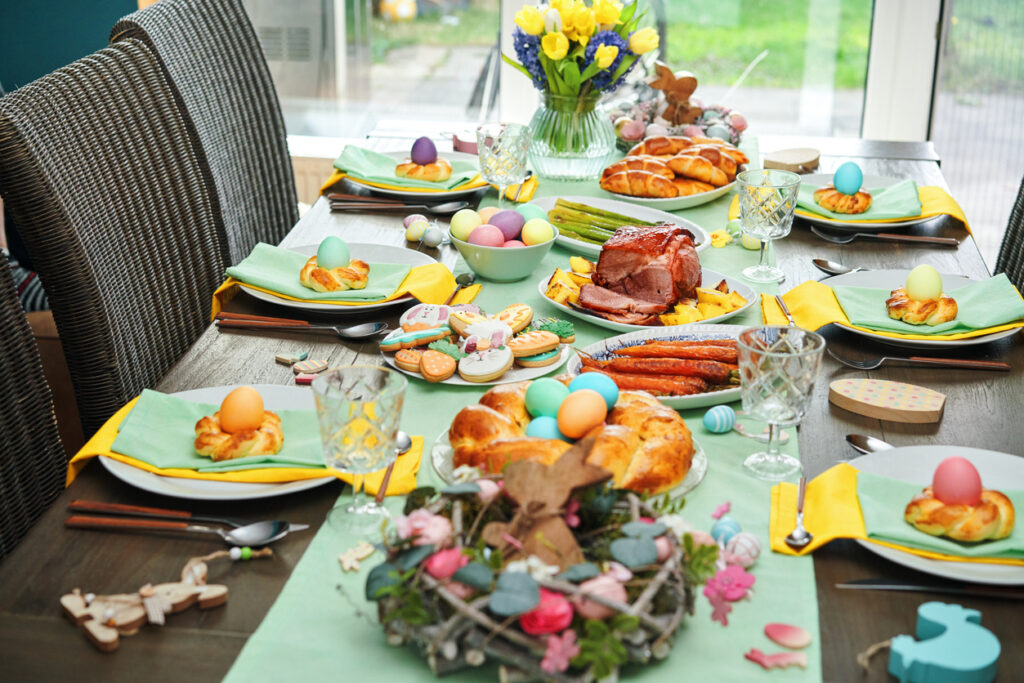 Pranzo di Pasqua con arrosto di maiale, verdure, biscotti pasquali e torta pasquale