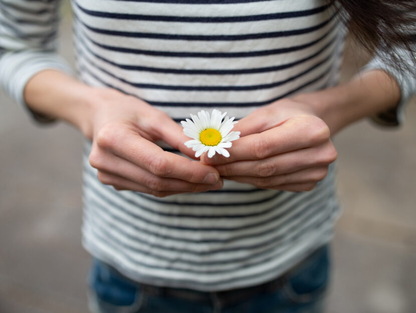 Ragazza margherita in mano