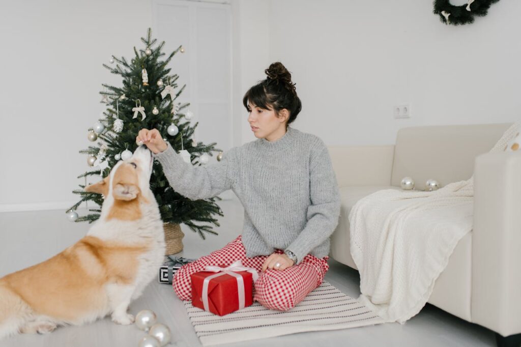 ragazza in sala con l'albero di natale e il cane