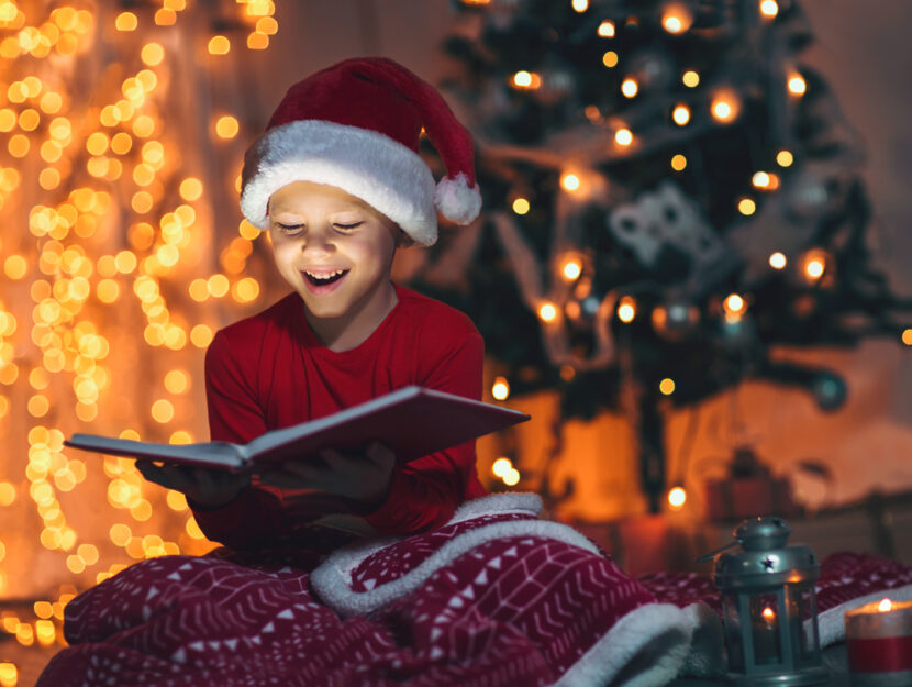 Bambino legge libro Natale