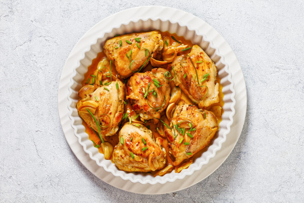 Cosce di pollo al sugo su teglia bianca