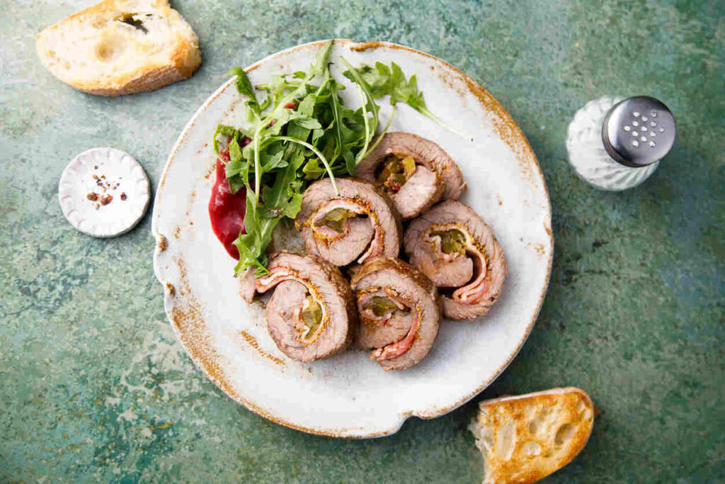 rotolo di maiale farcito in piatto