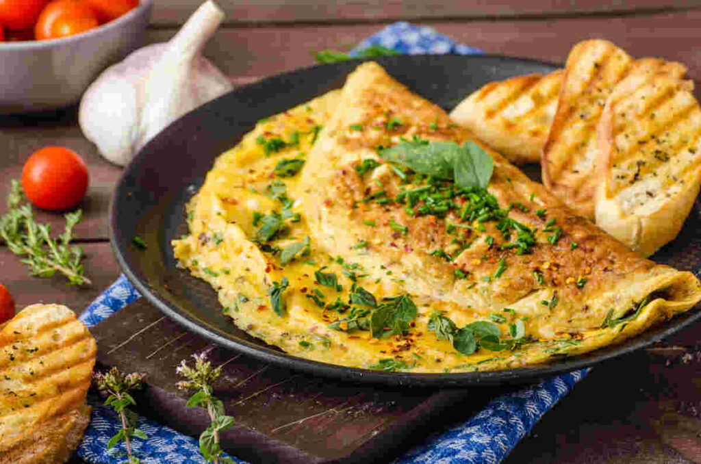 Frittata ripiegata con erba cipollina e pane su piatto nero