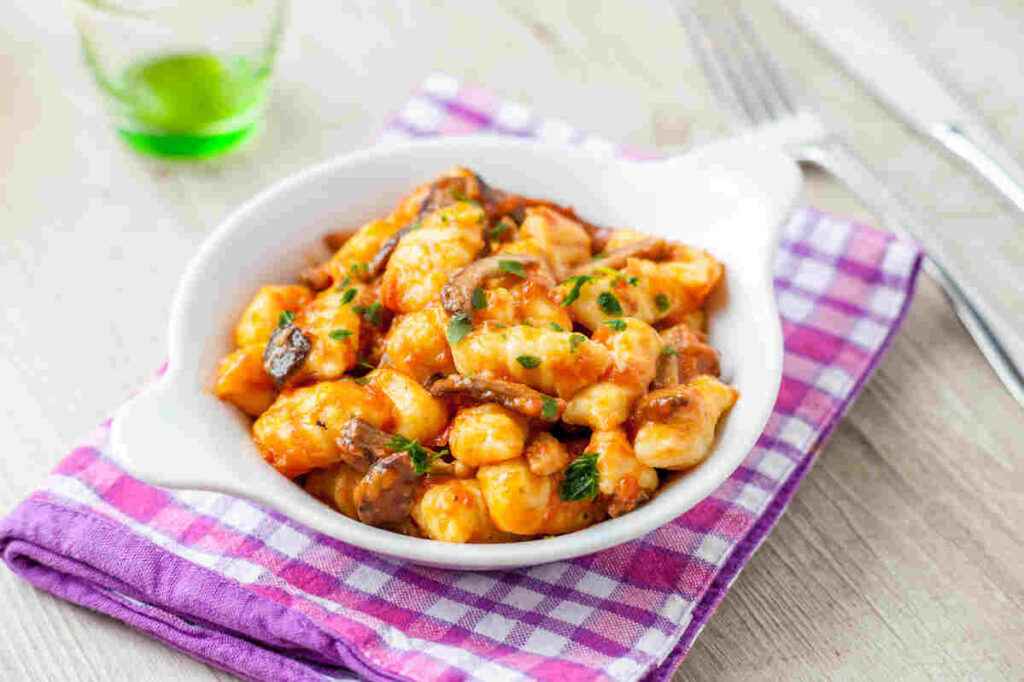 piatto di gnocchi al sugo su canovaccio a quadretti