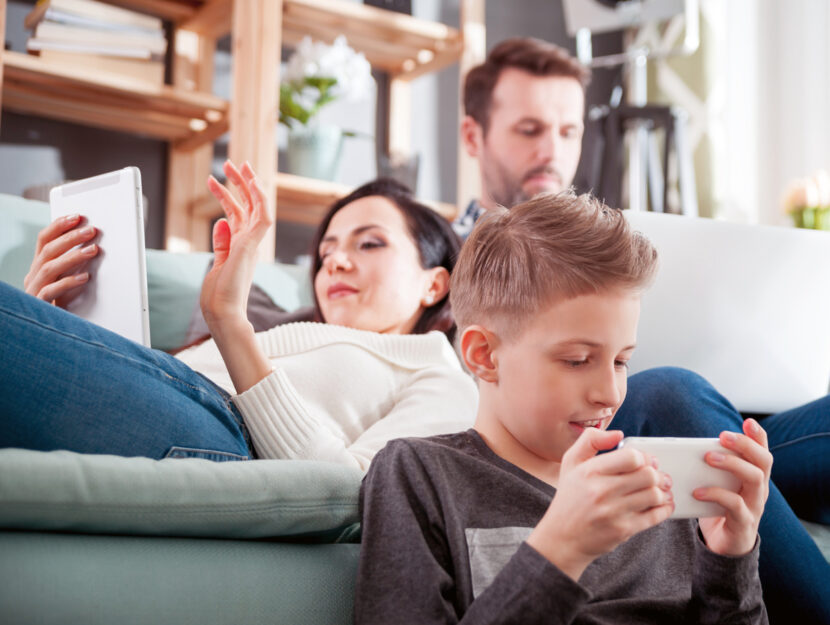 Bambino genitori computer smartphone casa divano