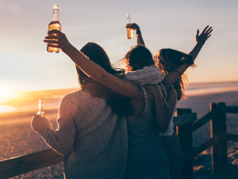 Amiche bevono una birra al tramonto