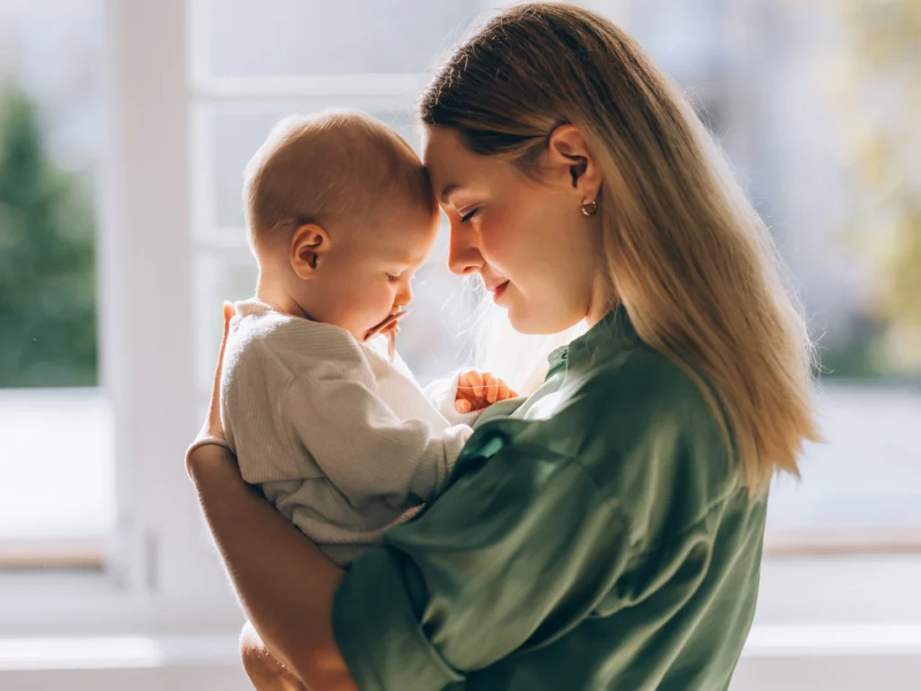 Una mamma tiene in braccio suo figlio piccolo, con una luce tra i due