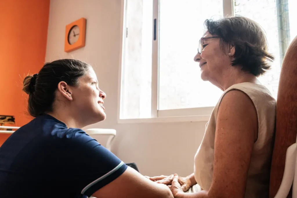 Un'operatrice sanitaria che assiste una donna anziana