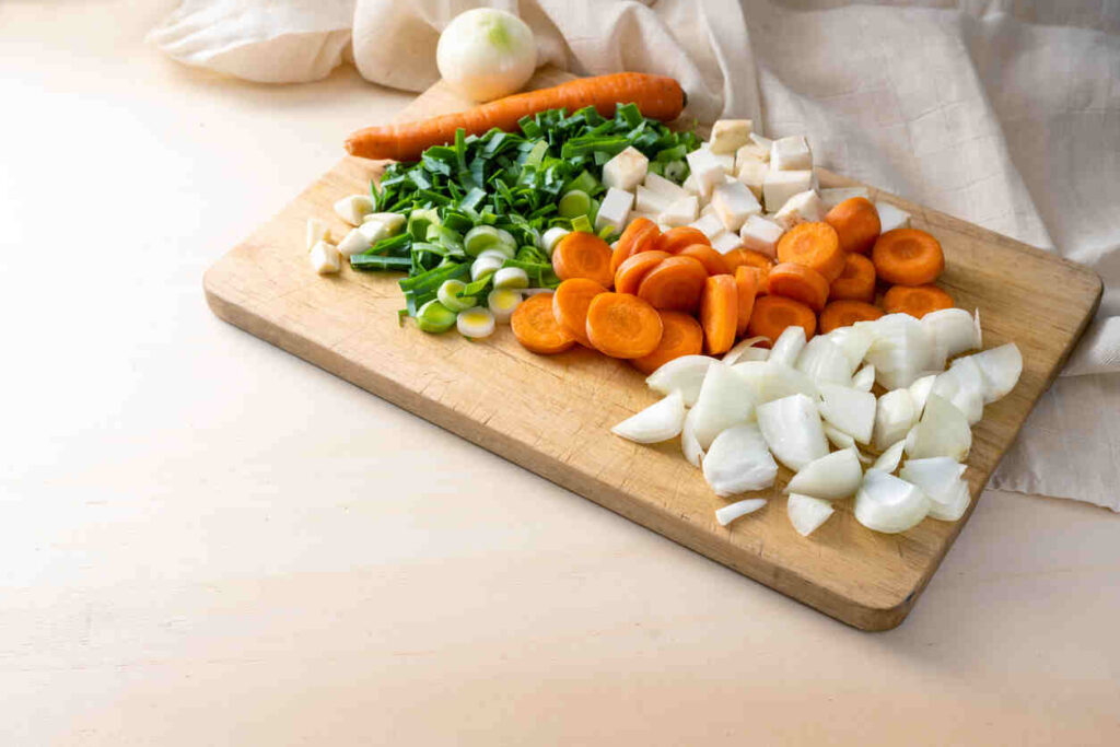 tagliere con carote cipolla sedano tagliati