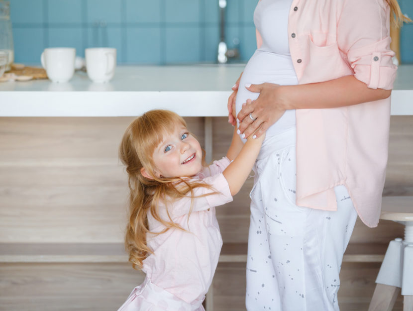 Bambina mamma con pancione in cucina