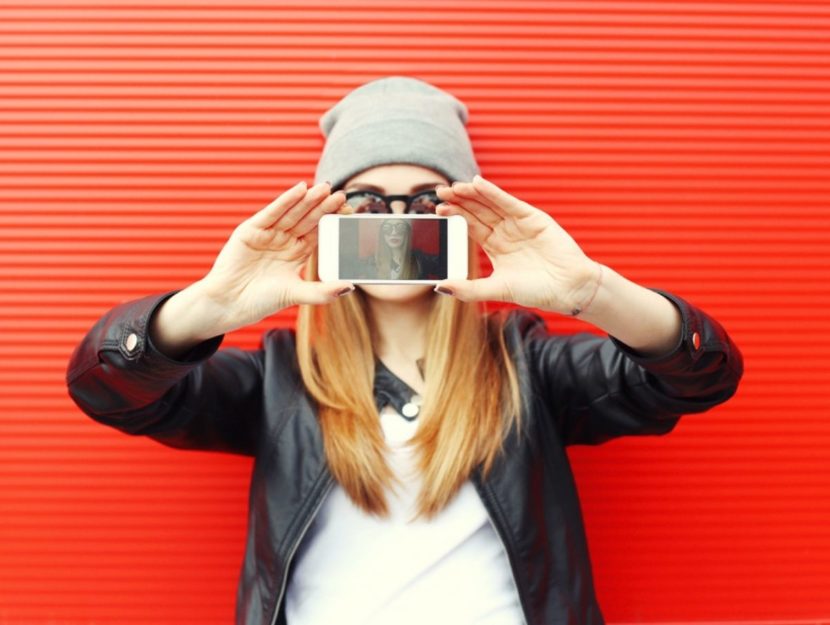 Donna con in mano cellulare selfie